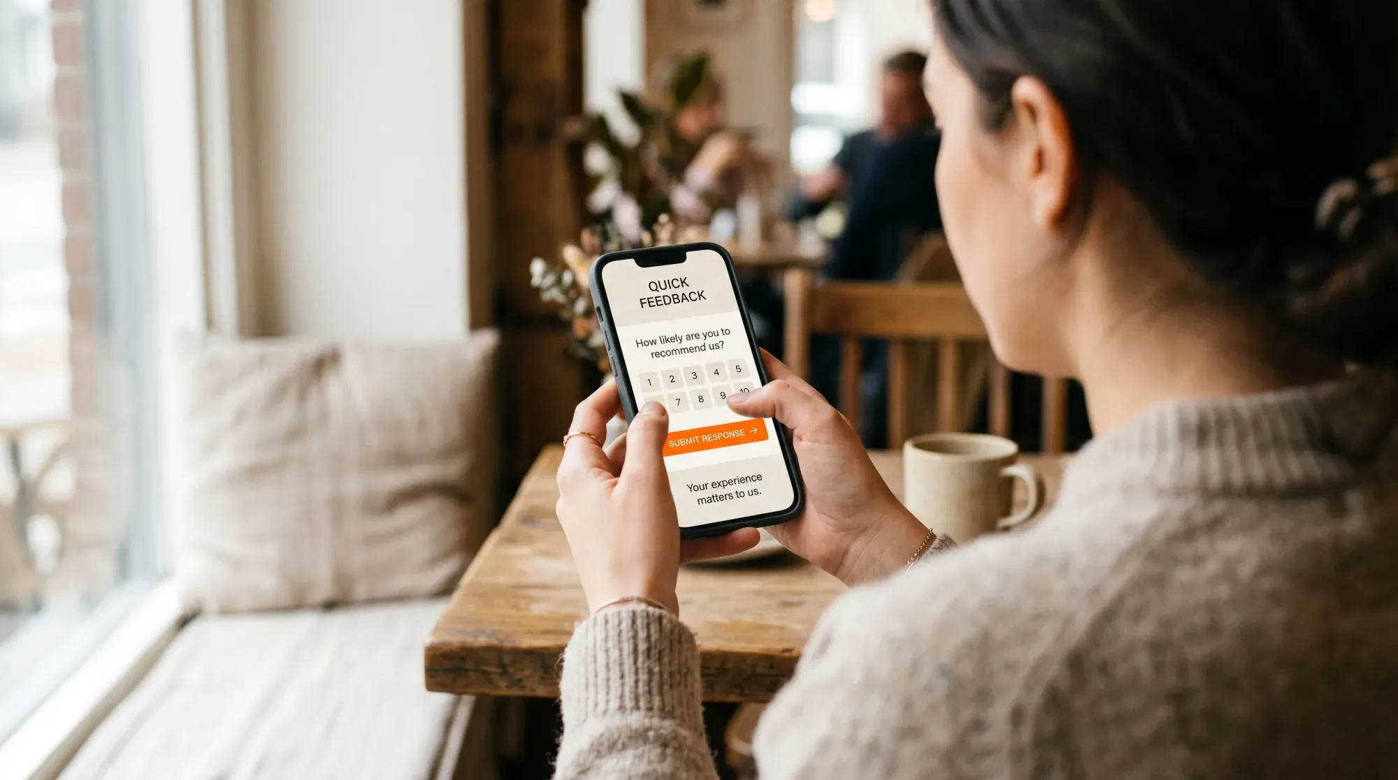 A person answering an in-app SurveyTale feedback survey on a phone in a café